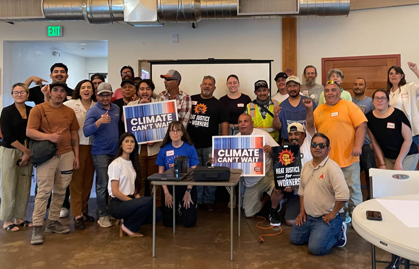 People gathered together for a picture. A few are holding signs that say Climate Can't Wait